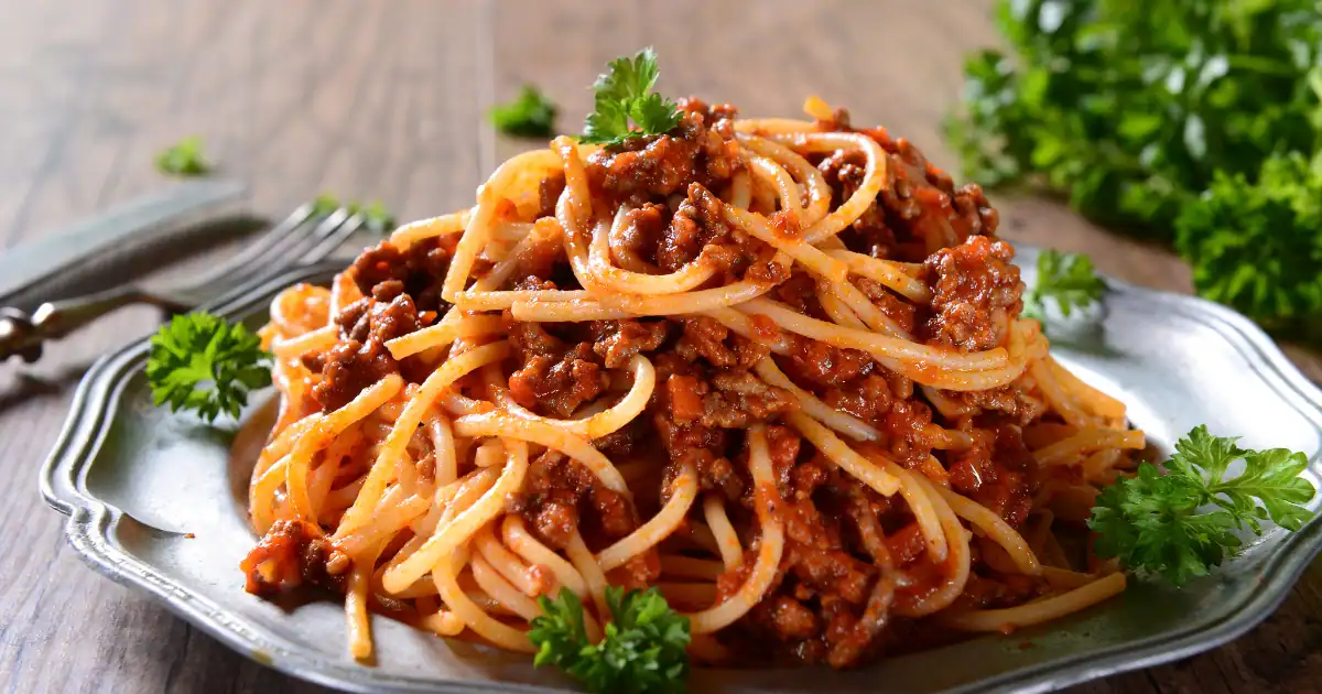 Kycklingfärs recept med krämig tomatsås och pasta, serverad med färska örter på en tallrik – en lättlagad och god vardagsrätt.